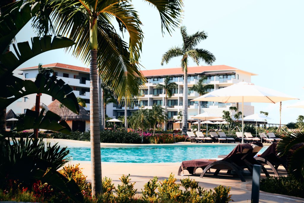 Resort pool and hotel surrounded by palm trees