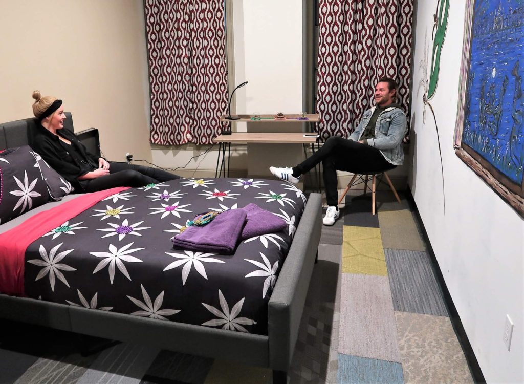 queen bed in private room, person sitting on chair in corner at City House Hostel