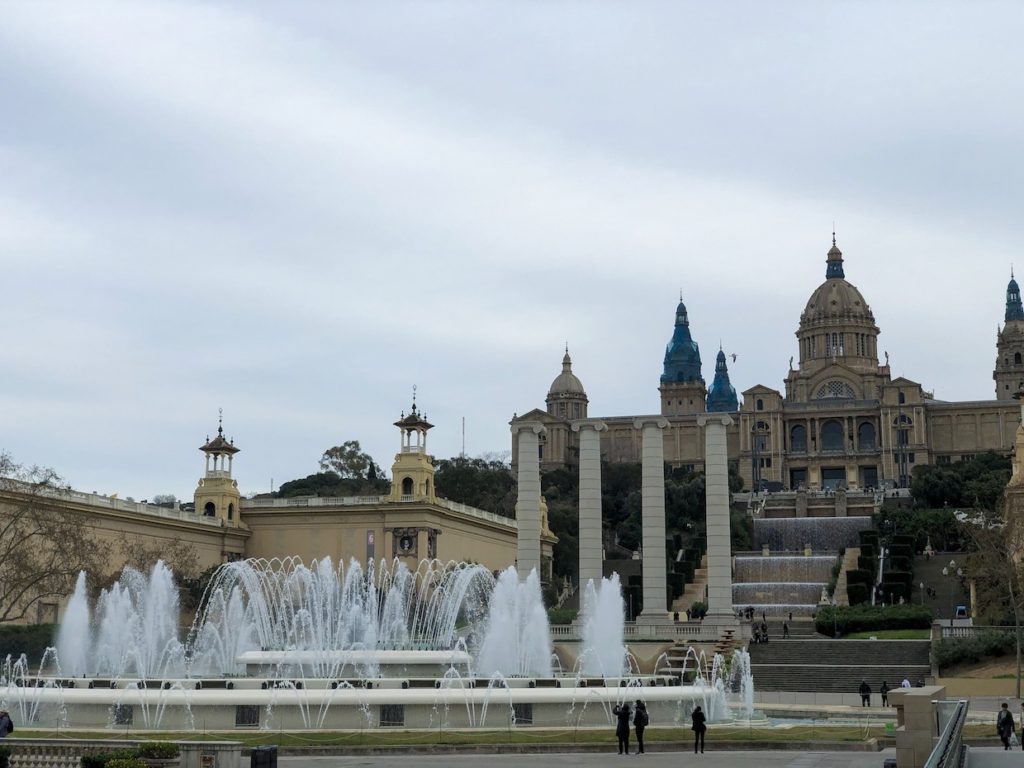 A fountain in front of an ornate building in Barcelona