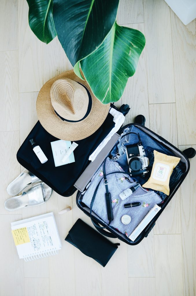 Open suitcase on the floor with items packed inside.