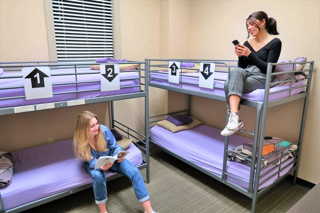 2 bunk beds with 2 women sitting on beds at City House Hostel