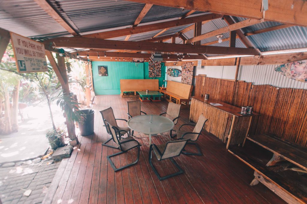 Wooden common space with table, benches, and darts at Banana Bungalow Hostel