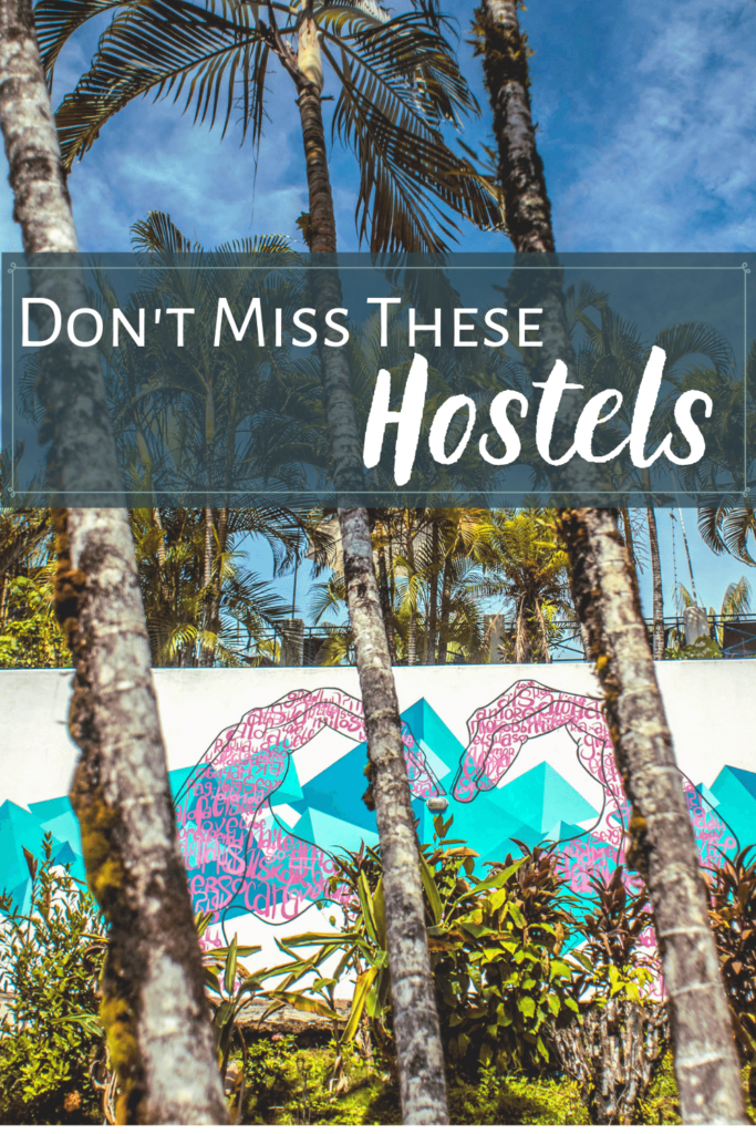 Background: Palm trees in front of a wall. Painted on the white wall are two pink hands in the shape of a heart. Text: Don't miss these hostels