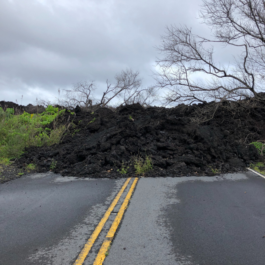 Cooled, black lava flow covers a road.