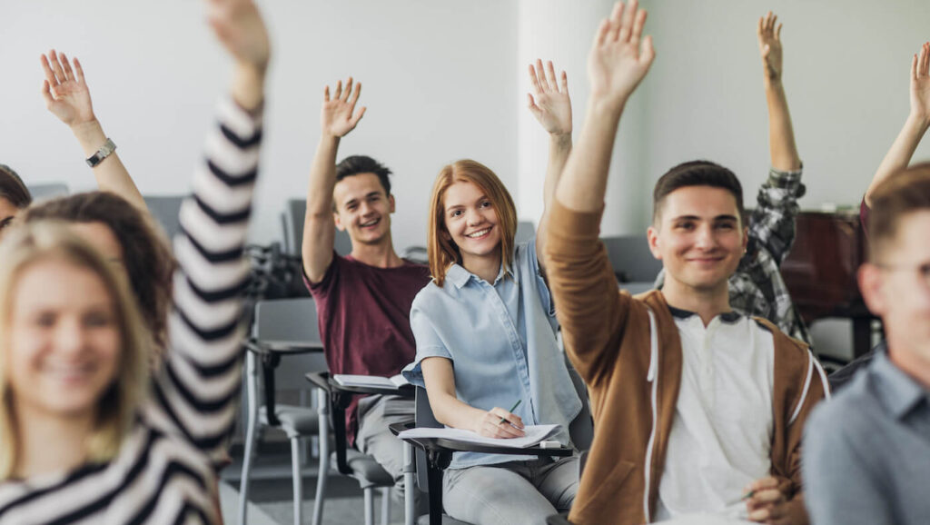 Students in class raising hands